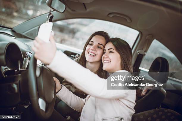 twee vrouwtjes selfie in auto te maken voor reizen - op hol geslagen voertuig stockfoto's en -beelden