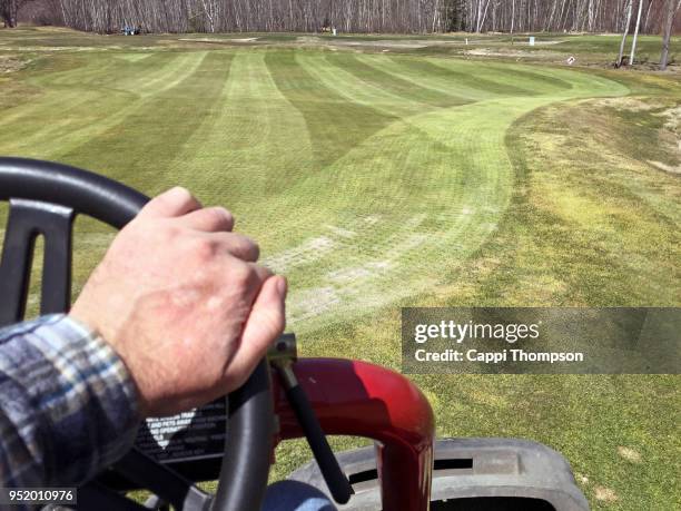 hand driving golf course triplex greens mower on golf course - golf course maintenance stock pictures, royalty-free photos & images