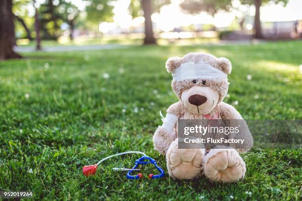 teddy bear patient sitting in the park - toy doctor kit stock pictures, royalty-free photos & images