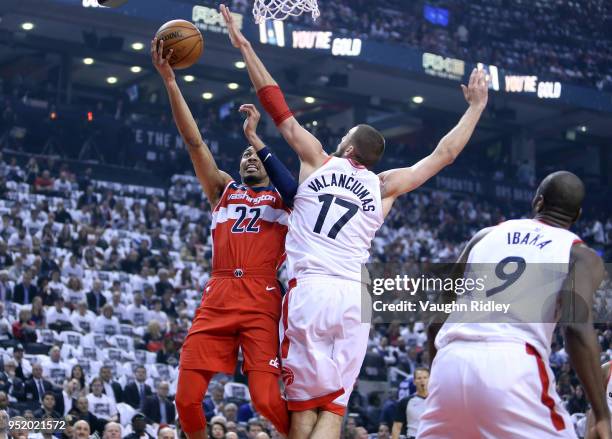 Otto Porter Jr. #22 of the Washington Wizards shoots the ball as Jonas Valanciunas of the Toronto Raptors defends during the first half of Game Five...