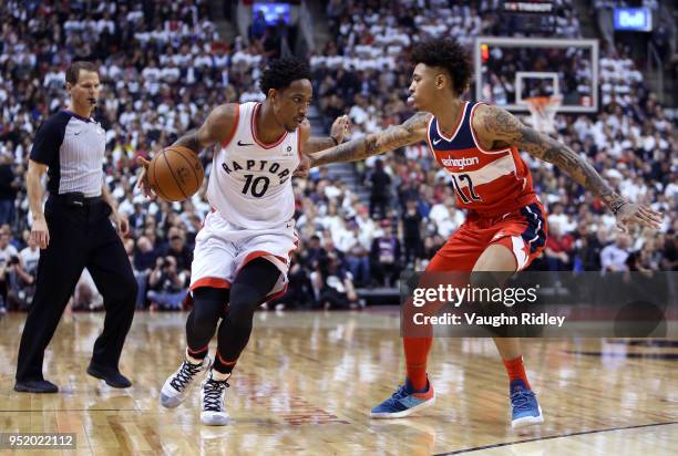 DeMar DeRozan of the Toronto Raptors dribbles the ball as Kelly Oubre Jr. #12 of the Washington Wizards defends during the second half of Game Five...