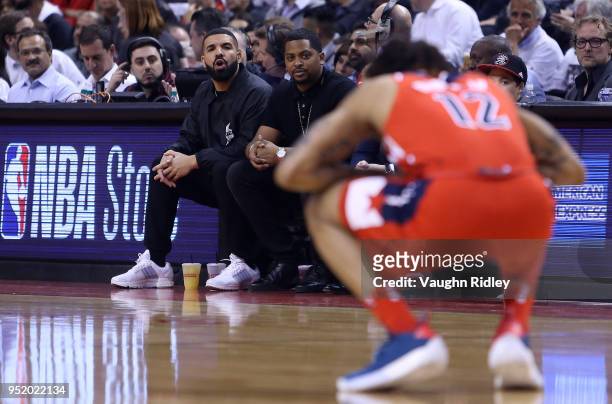 Singer Drake shouts to Kelly Oubre Jr. #12 of the Washington Wizards from his courtside seat during the second half of Game Five against the Toronto...