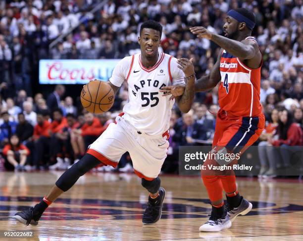 Delon Wright of the Toronto Raptors dribbles the ball as Ty Lawson of the Washington Wizards defends during the second half of Game Five in Round One...