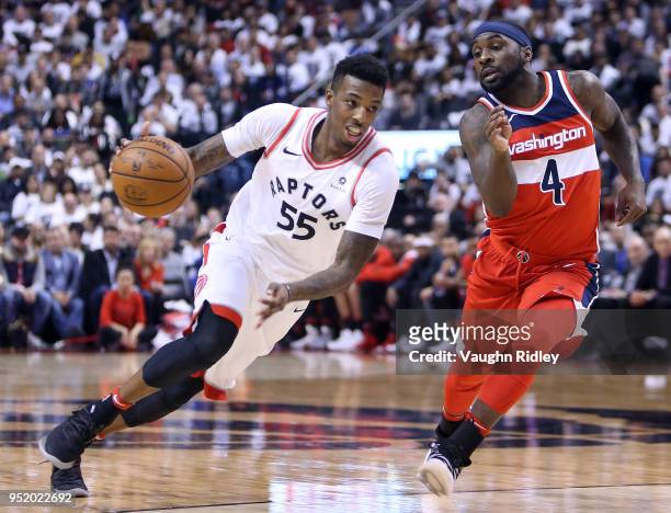 Delon Wright of the Toronto Raptors dribbles the ball as Ty Lawson of the Washington Wizards defends during the second half of Game Five in Round One...