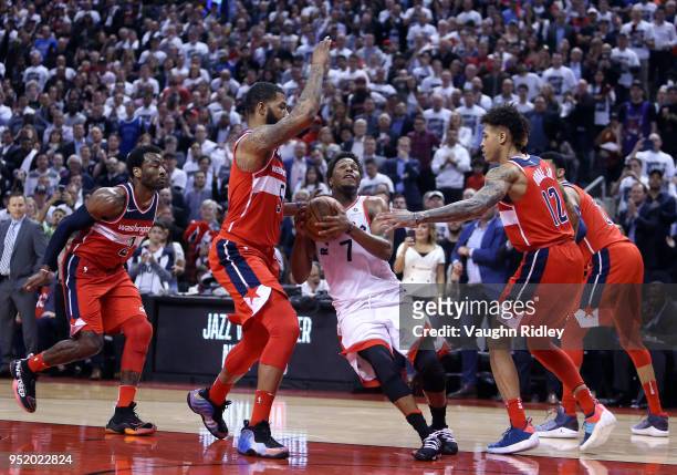 Kyle Lowry of the Toronto Raptors drives to the basket as Markieff Morris and Kelly Oubre Jr. #12 of the Washington Wizards defend during the second...