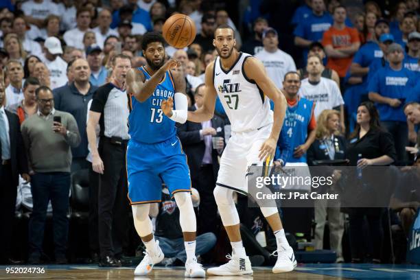 Paul George of the Oklahoma City Thunder passes the ball as Rudy Gobert of the Utah Jazz applies pressure during game 5 of the Western Conference...