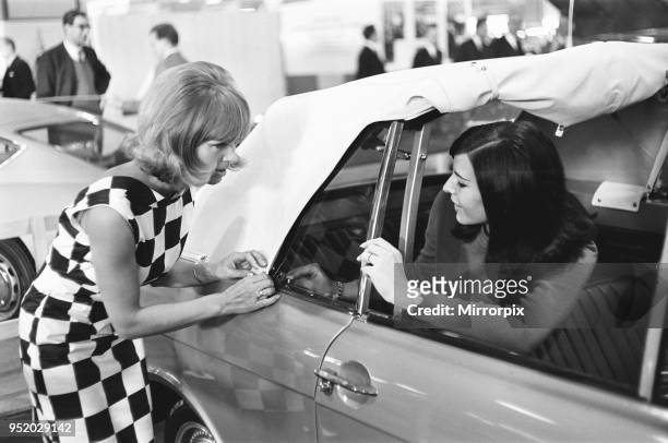 Models demonstrate the ease of lowering a soft top roof at the 1966 London Motor Show 18th October 1966. The soft top is in fact a Ford Cortina Mk2,...