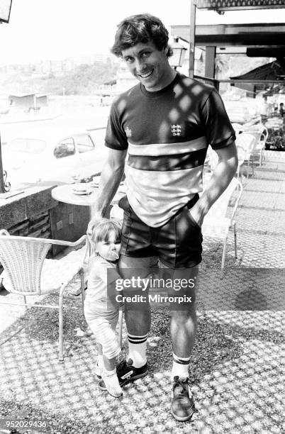 England footballer Kenny Sansom with his young daughter at the team base during the 1982 World Cup Finals in Spain, 16th June 1982.