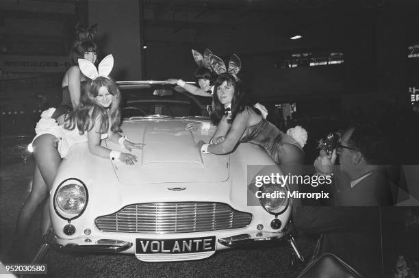 Bunny Girls drapped over an Aston Martin Volante car at the British International Motor Show in London 19th October 1965.