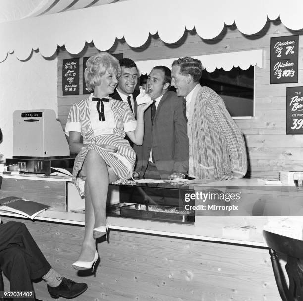 Everton football players Ray Wilson, Alex Scott and Sandy Brown being fed the house special barbecued chicken by waitress Margaret Jones after they...