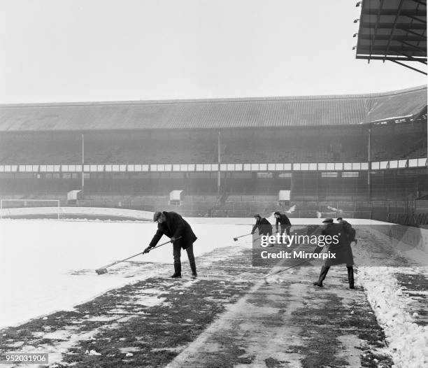 Groundsmen try to clear the snow from the pitch at Goodison Park, home ground of Everton Football Club, two days before their match against Bristol...