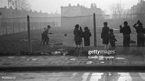 Life in the Mirror Our Gang, 19th January 1954 Boys playing football watched on by others on a bomb site off Bow Road in the East End of London.