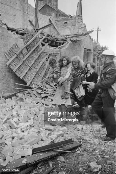 Shock on the faces of a family as they are assisted by an ARP warden after a raid, 1940.