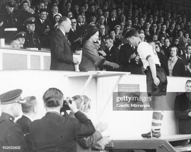 The Queen is seen here presenting medals to a member of the R.A.P.C. The losing side in the Army Association Football Cup Final at Aldershot. The...