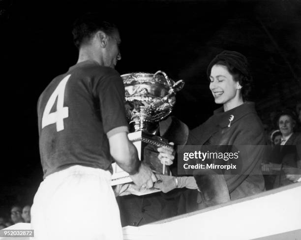 The Queen is seen here presenting the cup to Craftsman R. Nelson, Captain of the R.E.M.E team, who won one nil in the Army Association Football Cup...