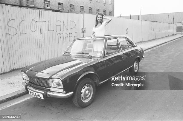 Reveille model Beulah Hughes seen here posing with a Peugeot 504 car which is a top prize in the Reveille win a car competition circa 1973.