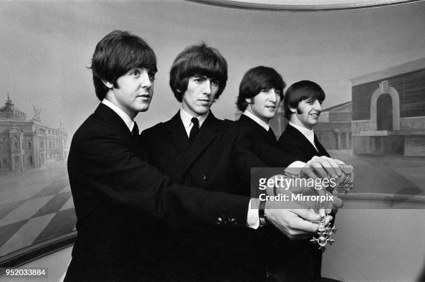 The Beatles show off their MBE medals after the royal investiture at Buckingham Palace, London, Tuesday 26th October 1965. The Beatles, each is now a...