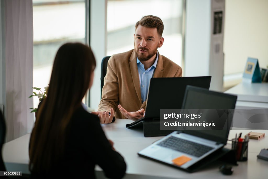 Young colleagues talking to each other in the office