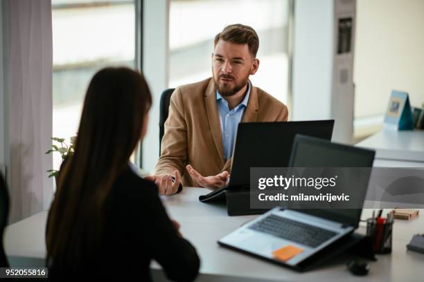 young colleagues talking to each other in the office - face to face interview stock pictures, royalty-free photos & images