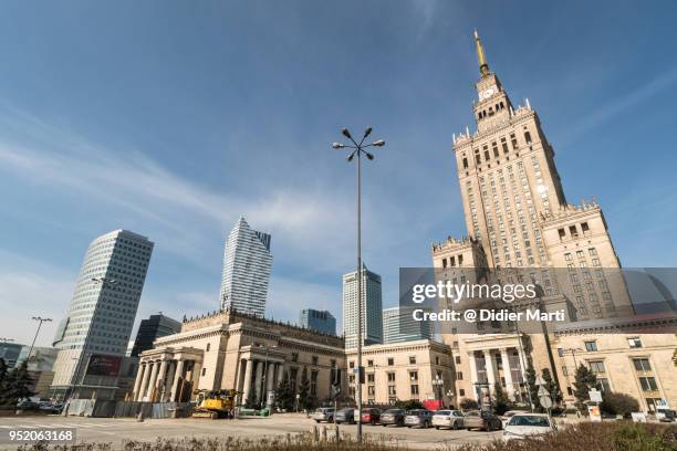 the communism era palace of culture and science contrasts with modern office buildings in warsaw - newly industrialized country imagens e fotografias de stock