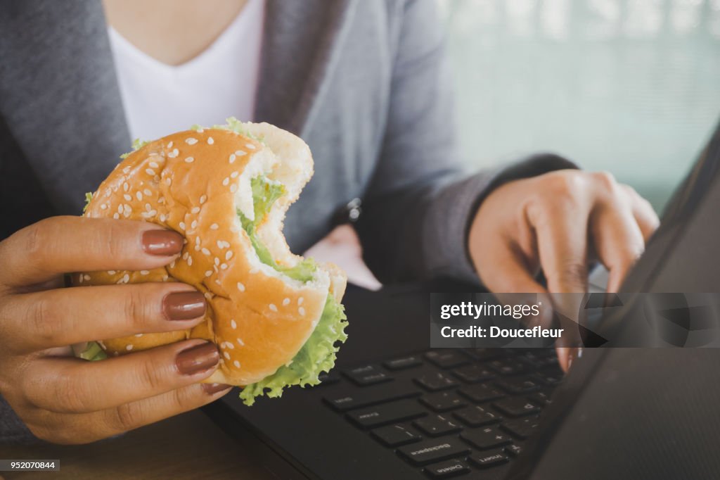 Eating A Computer Woman Eating Junk Food Burger While Working On Computer Laptop High-Res ...