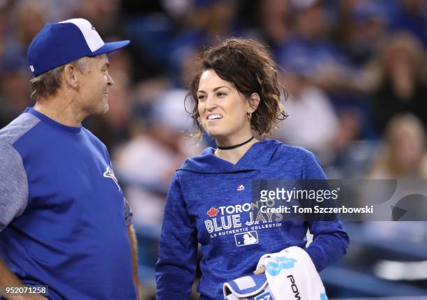 Head trainer Nikki Huffman of the Toronto Blue Jays talks to manager John Gibbons as she comes out onto the field in the first inning during MLB game...