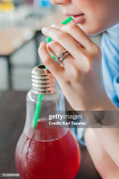 a woman is drinking a red juice from a straw - straw lips stock pictures, royalty-free photos & images