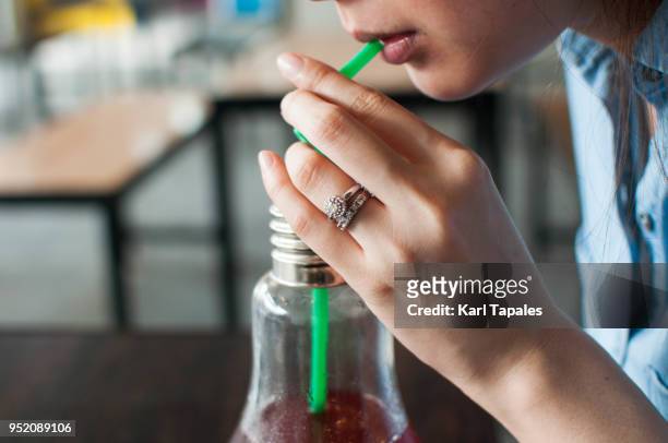a woman is drinking a red juice from a straw - straw lips stock pictures, royalty-free photos & images