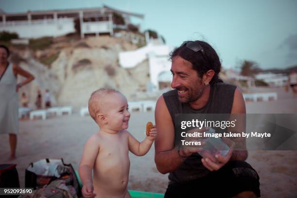 baby boy and uncle eating at the beach - uncle nephew stock pictures, royalty-free photos & images