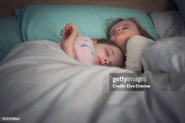 Two sisters asleep in bed