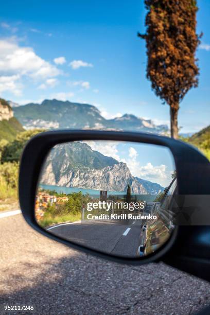 a reflection in a car's mirror at lake garda, italy - side view mirror stockfoto's en -beelden