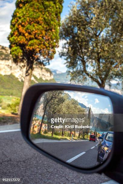 a reflection in a car's mirror at lake garda, italy - torbole stock pictures, royalty-free photos & images