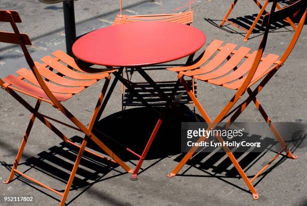 empty orange cafe table and chairs with shadows - lyn holly coorg stock-fotos und bilder