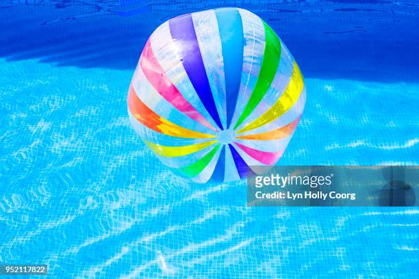 multi coloured beach ball in swimming pool - lyn holly coorg stock pictures, royalty-free photos & images