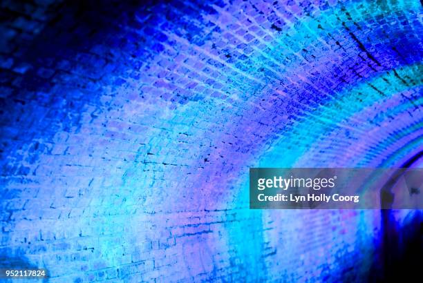 defocussed blue and purple lights at night in tunnel - lyn holly coorg stock pictures, royalty-free photos & images