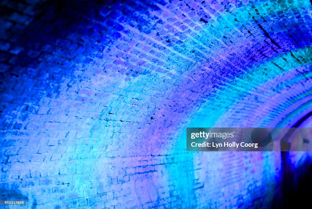 Defocussed blue and purple lights at night in tunnel