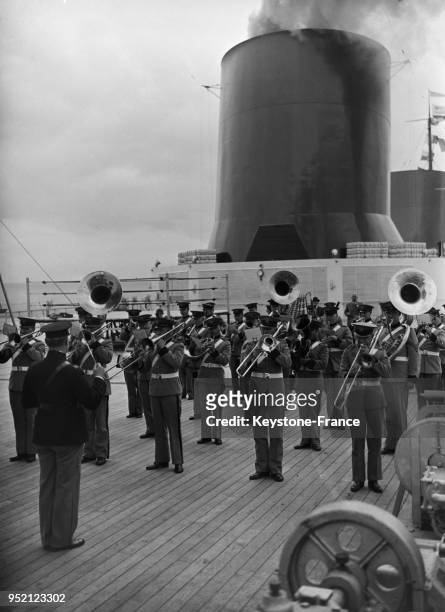Sur le pont, au pied de la cheminée du 'Normandie', l'orchestre de la Garde américaine joue la Marseillaise à son arrivée au Havre, France en 1935.