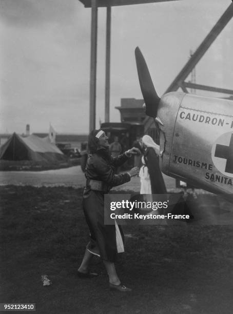 Une infirmière mettant en marche l'hélice d'un avion, au Bourget, France en 1934.