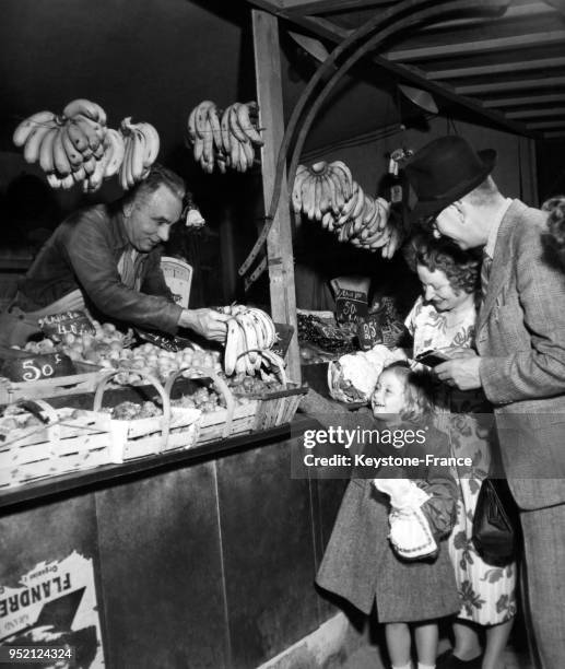 Une famille de touristes anglais achètent des bananes chez un primeur à leur arrivée à Boulogne, en 1946 à Boulogne-sur-Mer, France.