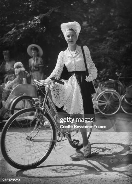 Femme élégante à vélo à l'hippodrome de Chantilly, France en 1943.