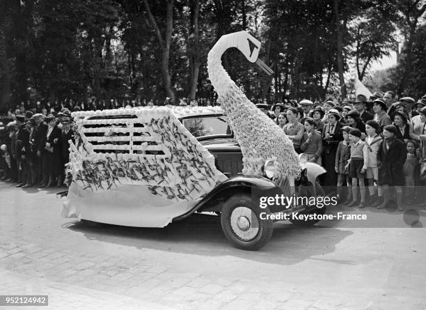 Défilé des chars de carnaval fleuris pendant la fête du muguet à Rambouillet, France en mai 1933.