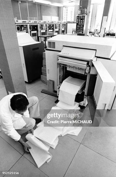 Technicien réparant une immrimante dans la salle informatique de la Caisse d'Allocations Familiales de Dijon, en 1983, en Côte-d'Or, France.