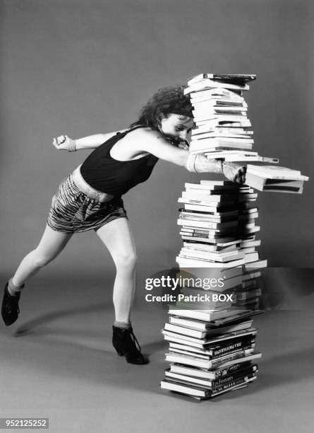 Jeune femme tapant du poing dans une pile de livres, à Martigues, en septembre 1987, dans les Bouches-du-Rhône, France.