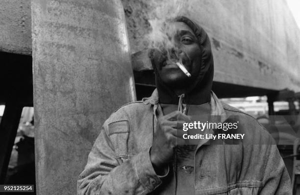 Ouvrier immigré fumant une cigarette sur un chantier à Saint-Denis, en 1993, en Seine-Saint-Denis, France.