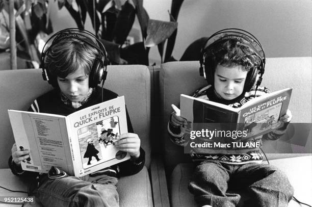 Enfants lisant des bandes dessinnées ?Quick et Flupke? en écoutant de la musique dans la discothèque de la bibliothèque de Miramas, en 1983, dans les...