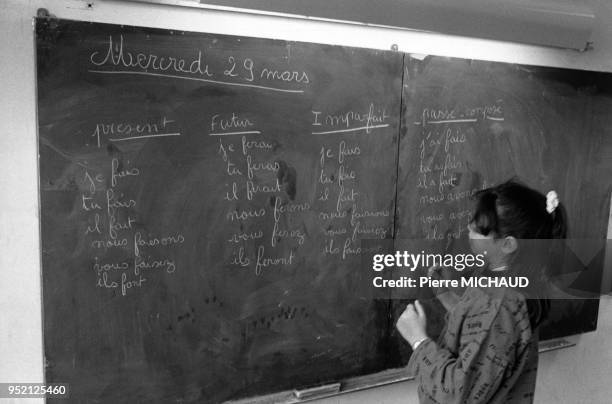 Petite fille faisant de la conjugaison au tableau dans une école primaire à Concarneau, dans le Finistère, France.