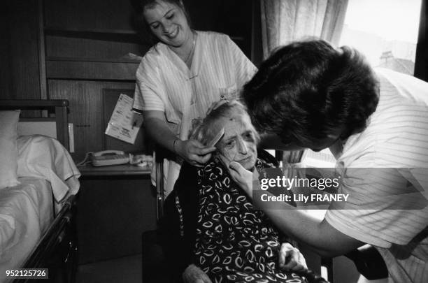 Aides soignantes coiffant une femme âgée dans le centre de gérontologie de l'hôpital du Kremlin-Bicêtre, en 1997, dans le Val-de-Marne, France.