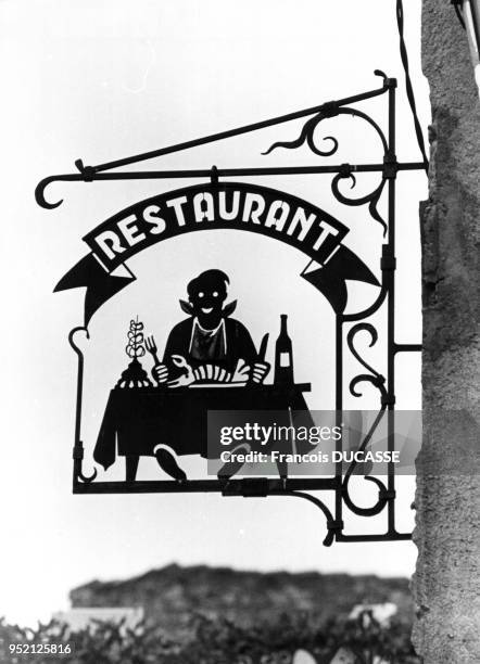 Enseigne en fer forgé d'un restaurant à Villefranche-de-Conflent, en 1983, dans les Pyrénées-Orientales, France.