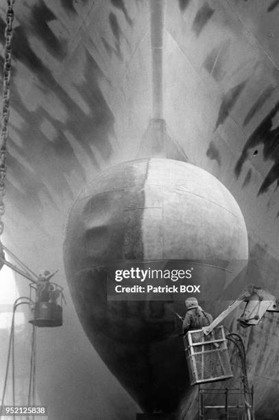 Sablage de la coque d'un bateau dans un chantier naval à Marseille, dans les Bouches-du-Rhônes, en 1985, France.