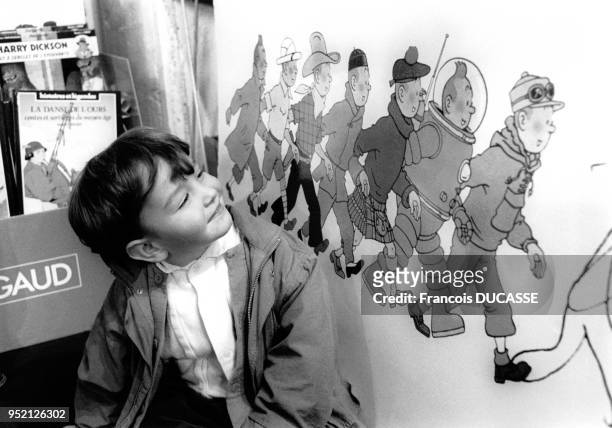 Enfant obersant une affiche de ?Tintin? au salon du livre à Bordeaux, en octobre 1994, en Gironde, France.